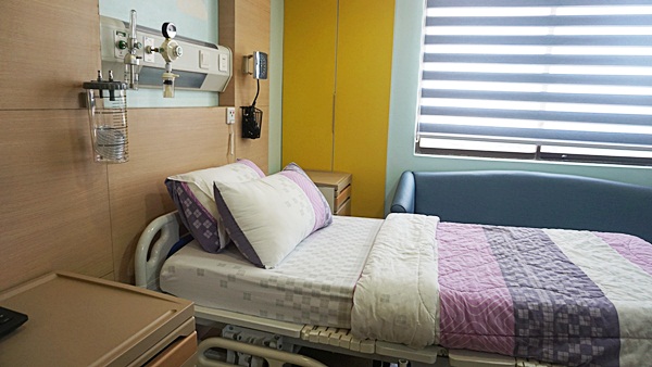The hospital room furniture and beds have soft cushions and comforters in colors that are fresh and lively.