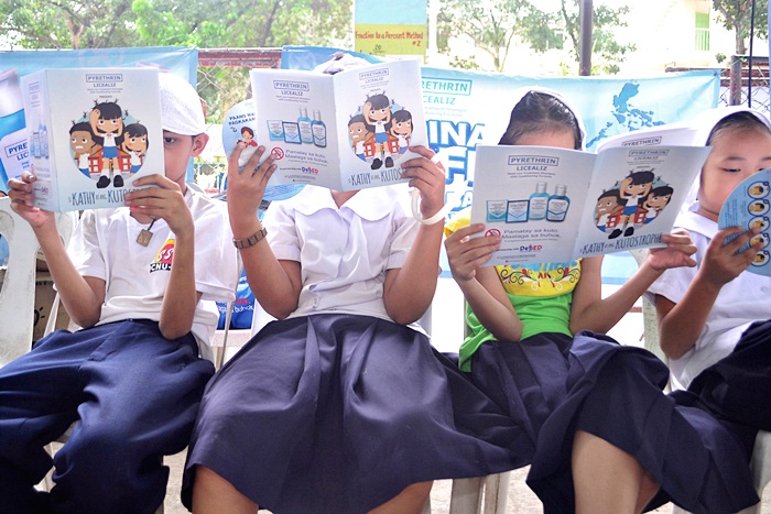Students read Licealiz’ Si Kathy at ang Kutostrophe story and coloring book after having their hair washed. 