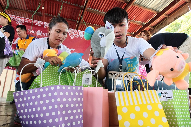 Employee volunteers of The SM Store prepare the plush toys for the gift-giving activity. 