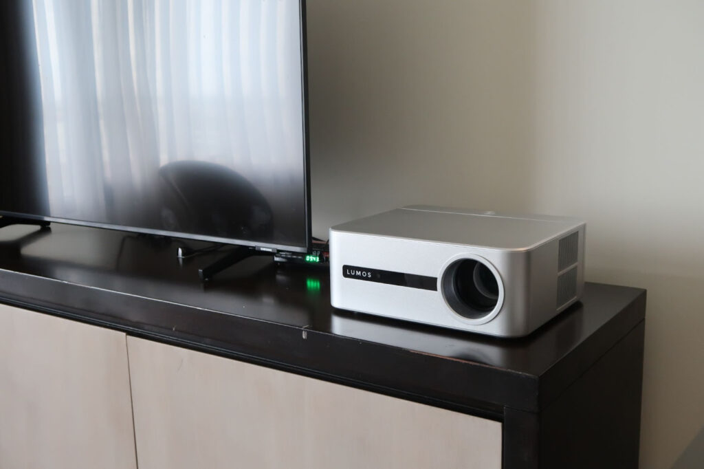 LUMOS Daystar projector placed on a TV console as a flexible home entertainment setup